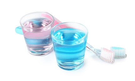 Glasses with mouthwash and toothbrushes on white background. Teeth hygiene