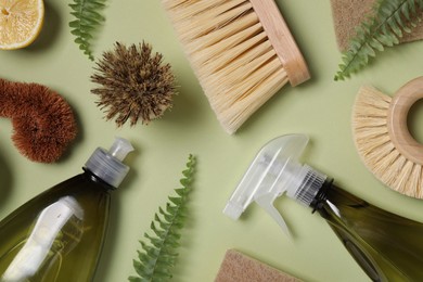 Photo of Flat lay composition with different cleaning supplies on green background