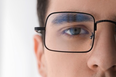 Photo of Man wearing glasses on light background, closeup