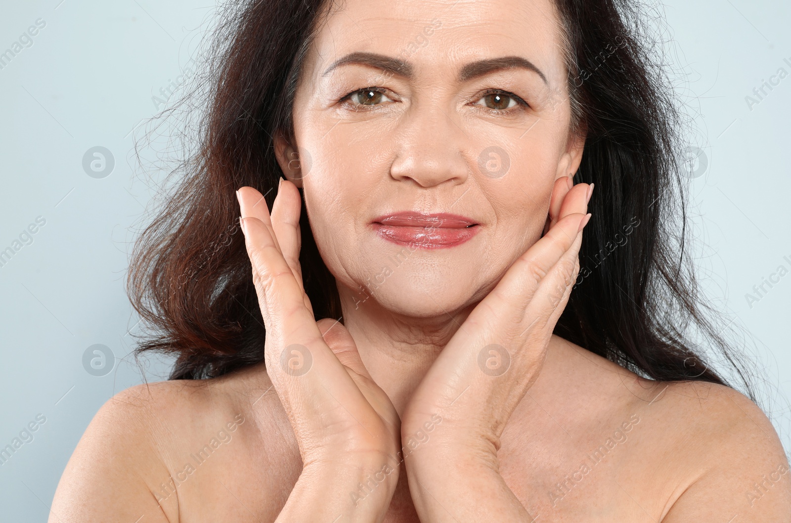 Photo of Portrait of mature woman with beautiful face on grey background