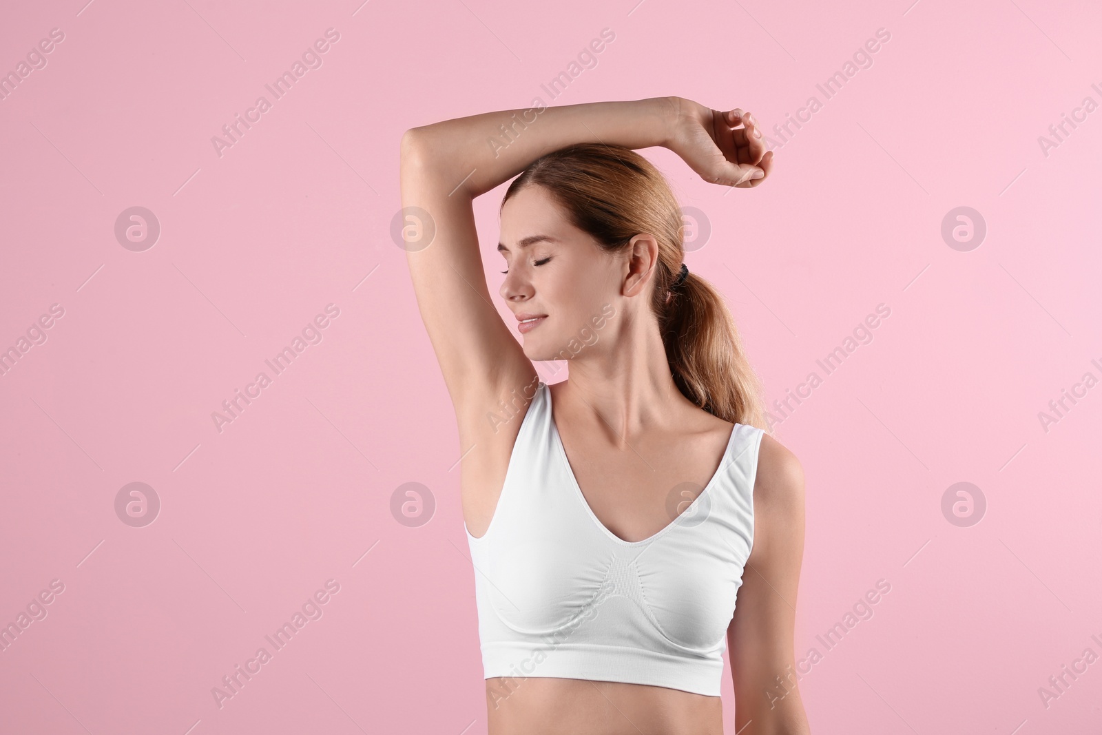 Photo of Young woman showing armpit on color background. Using deodorant