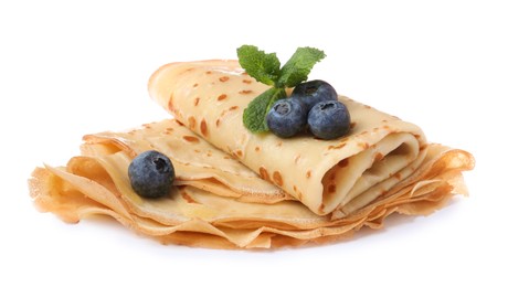 Photo of Delicious crepes with blueberries and mint on white background