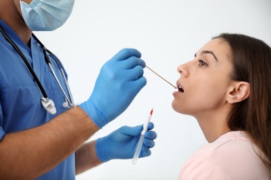 Doctor taking sample for DNA test from woman in clinic