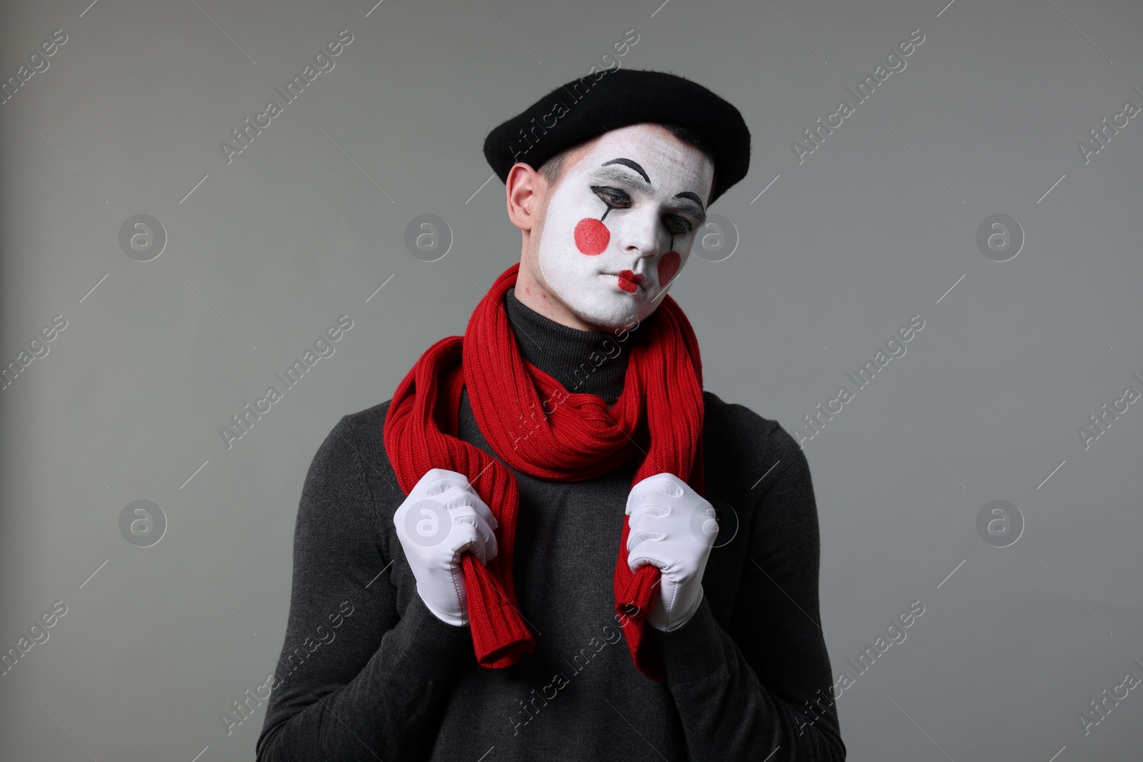 Photo of Portrait of mime artist in beret on grey background