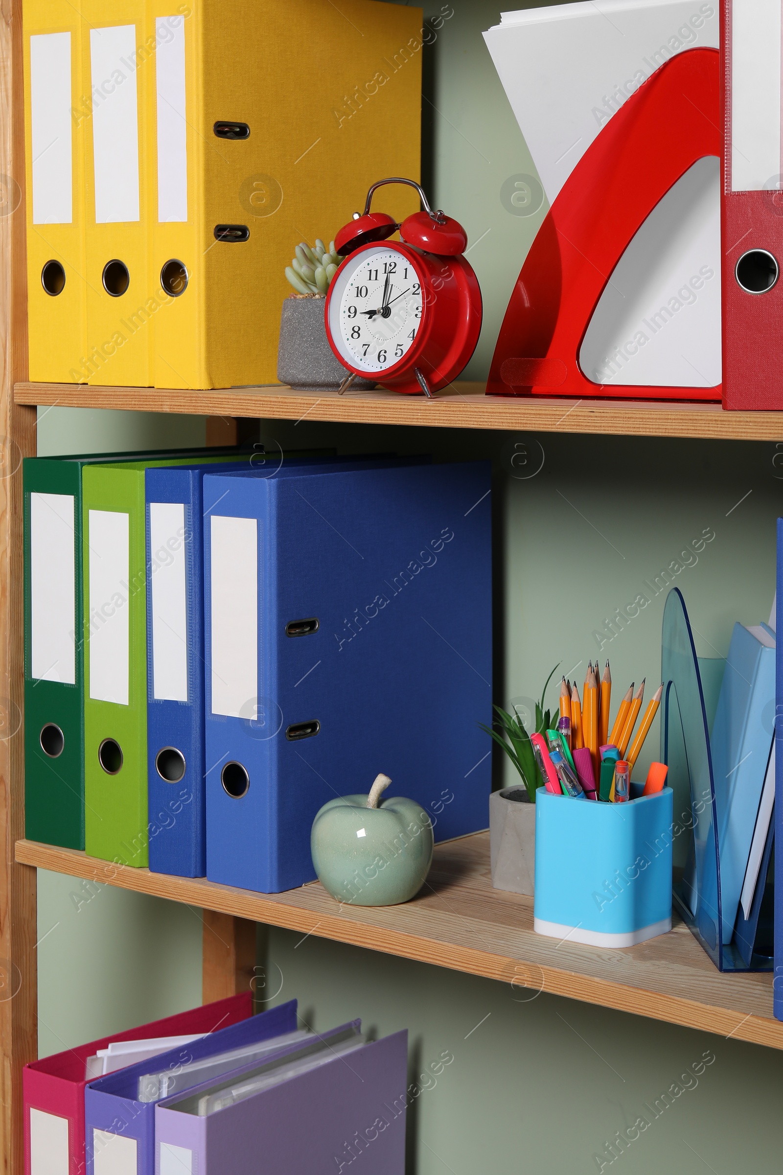 Photo of Colorful binder office folders and other stationery on shelving unit