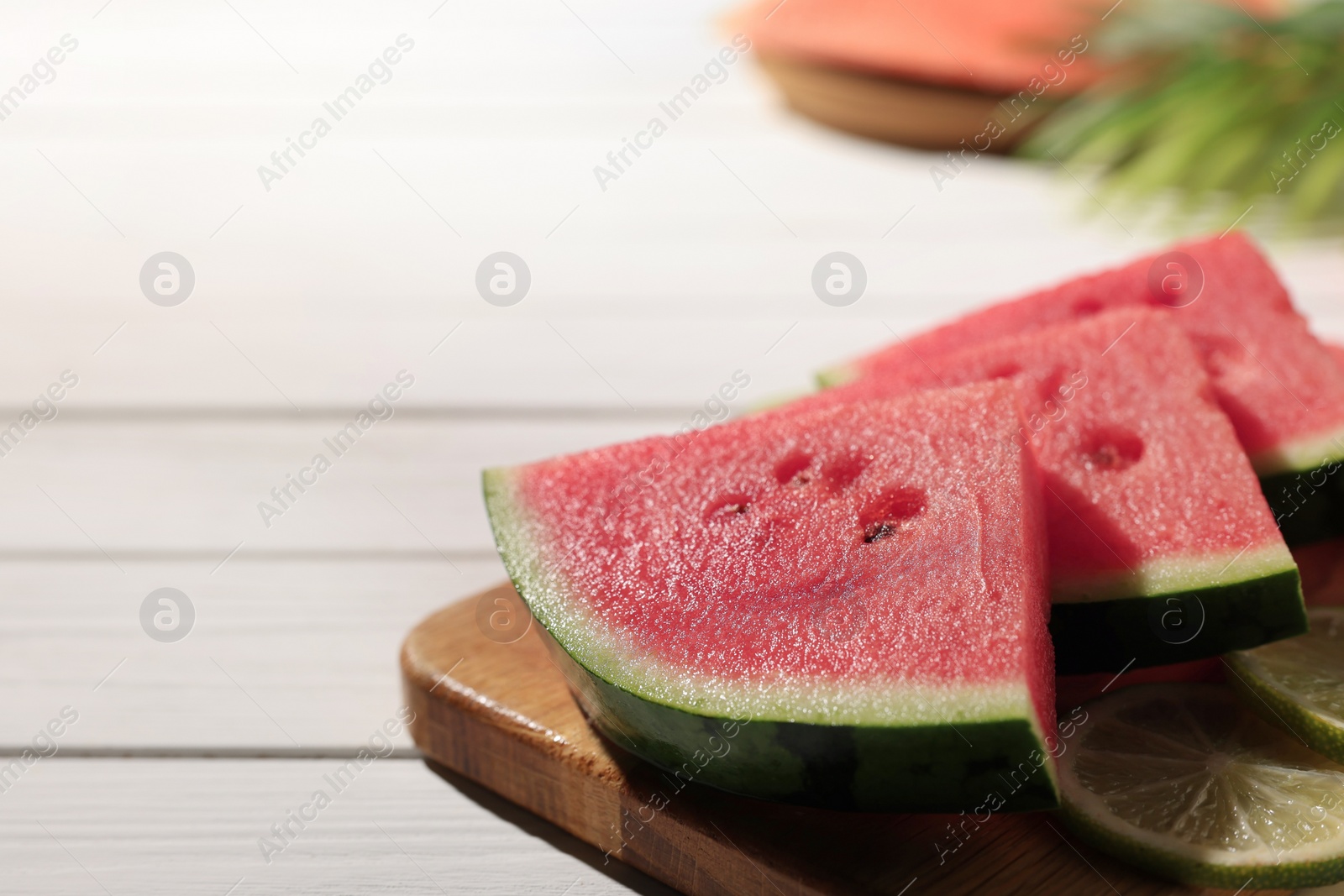 Photo of Tasty sliced watermelon and lime on white wooden table, closeup