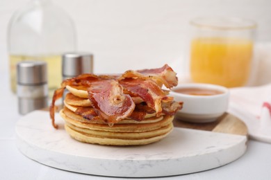 Delicious pancakes with bacon and honey on white table, closeup