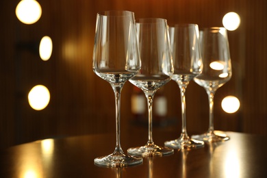 Photo of Empty wine glasses on table against blurred background
