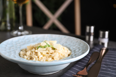 Photo of Delicious risotto with cheese on grey table, closeup