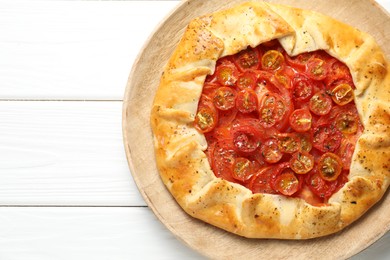 Tasty tomato galette (Caprese galette) on white wooden table, top view. Space for text