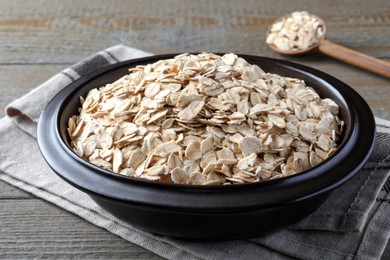 Photo of Bowl of oatmeal and spoon on wooden table, closeup