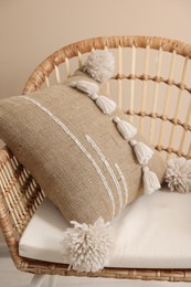 Photo of Stylish soft pillow on armchair near beige wall indoors