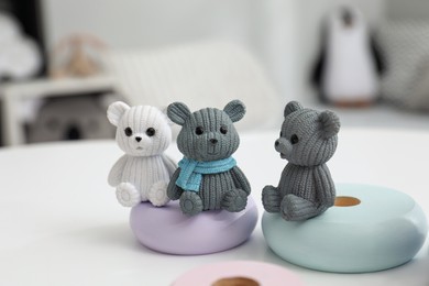 Photo of Different small toy bears on white table, closeup. Interior design