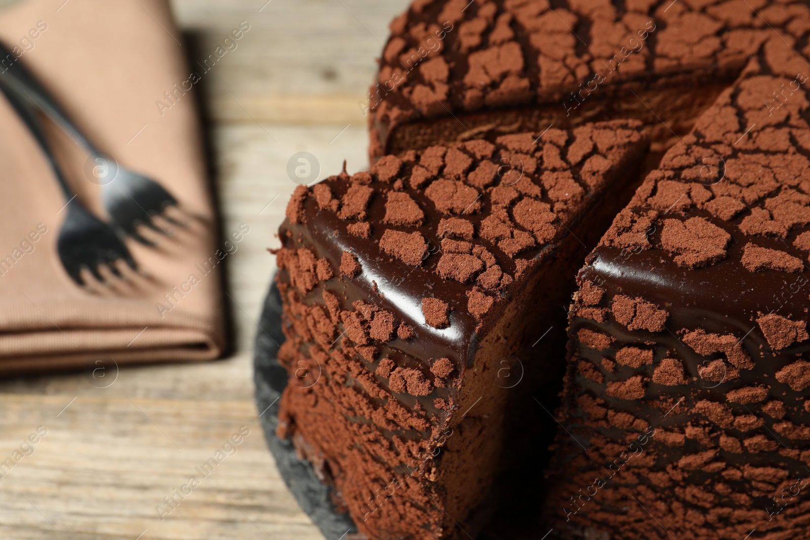 Photo of Delicious chocolate truffle cake on wooden table, closeup