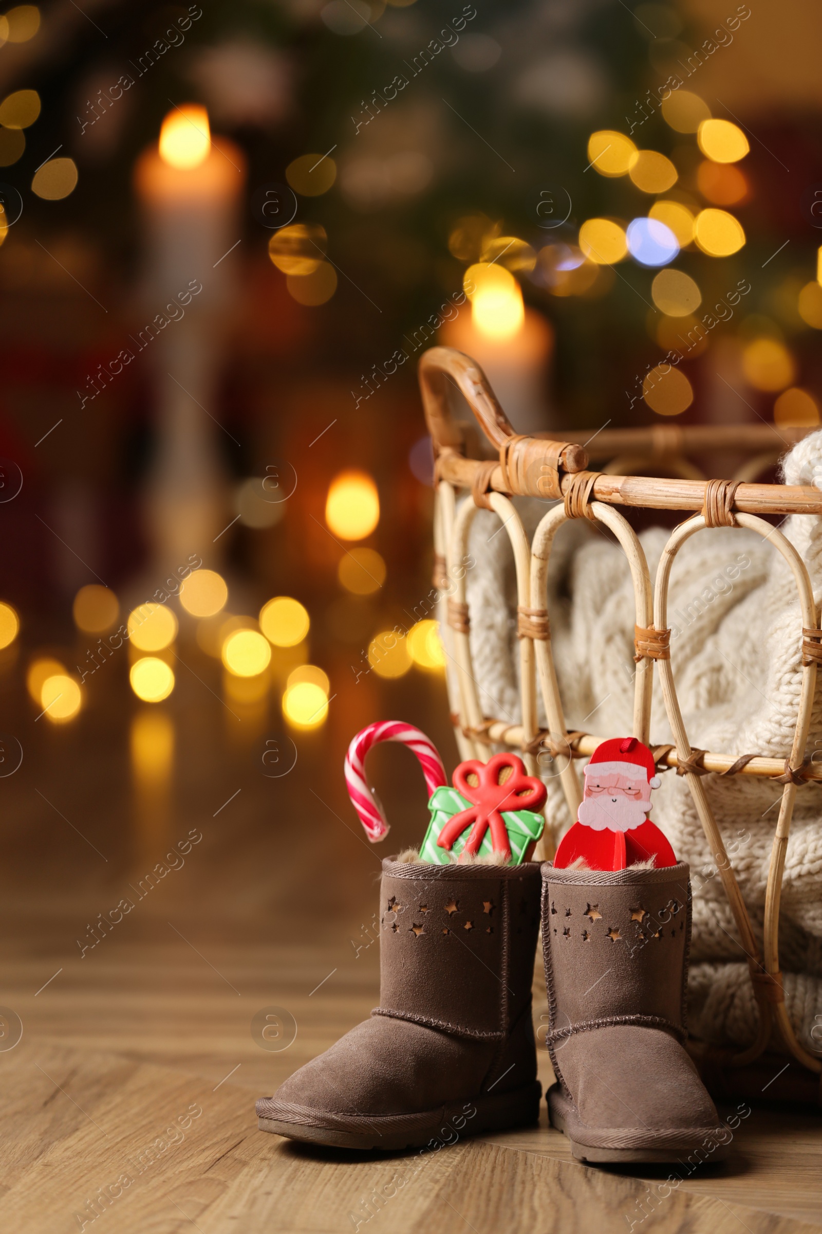 Photo of Boots filled with sweets on floor in room. Saint Nicholas Day