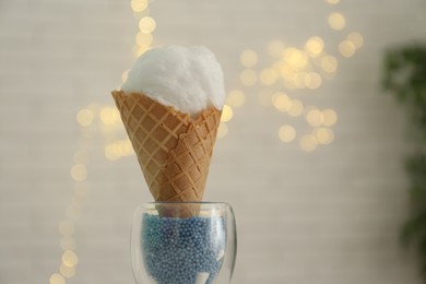 Cotton candy in waffle cone against blurred lights