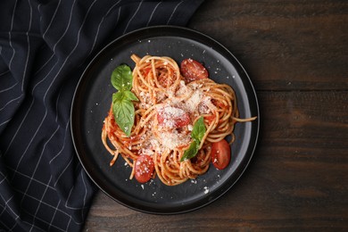 Tasty pasta with tomato sauce, cheese and basil on wooden table, top view