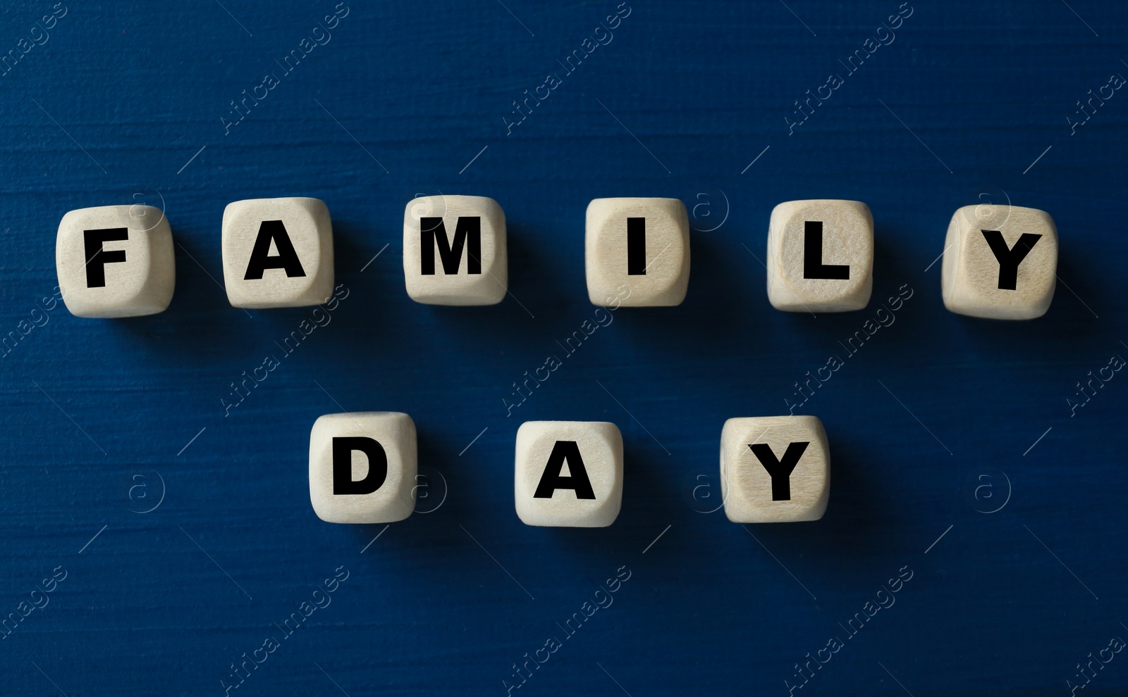 Photo of Wooden cubes with words Family Day on blue table, flat lay