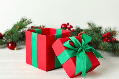 Photo of Red Christmas gift box with green bow on white wooden table