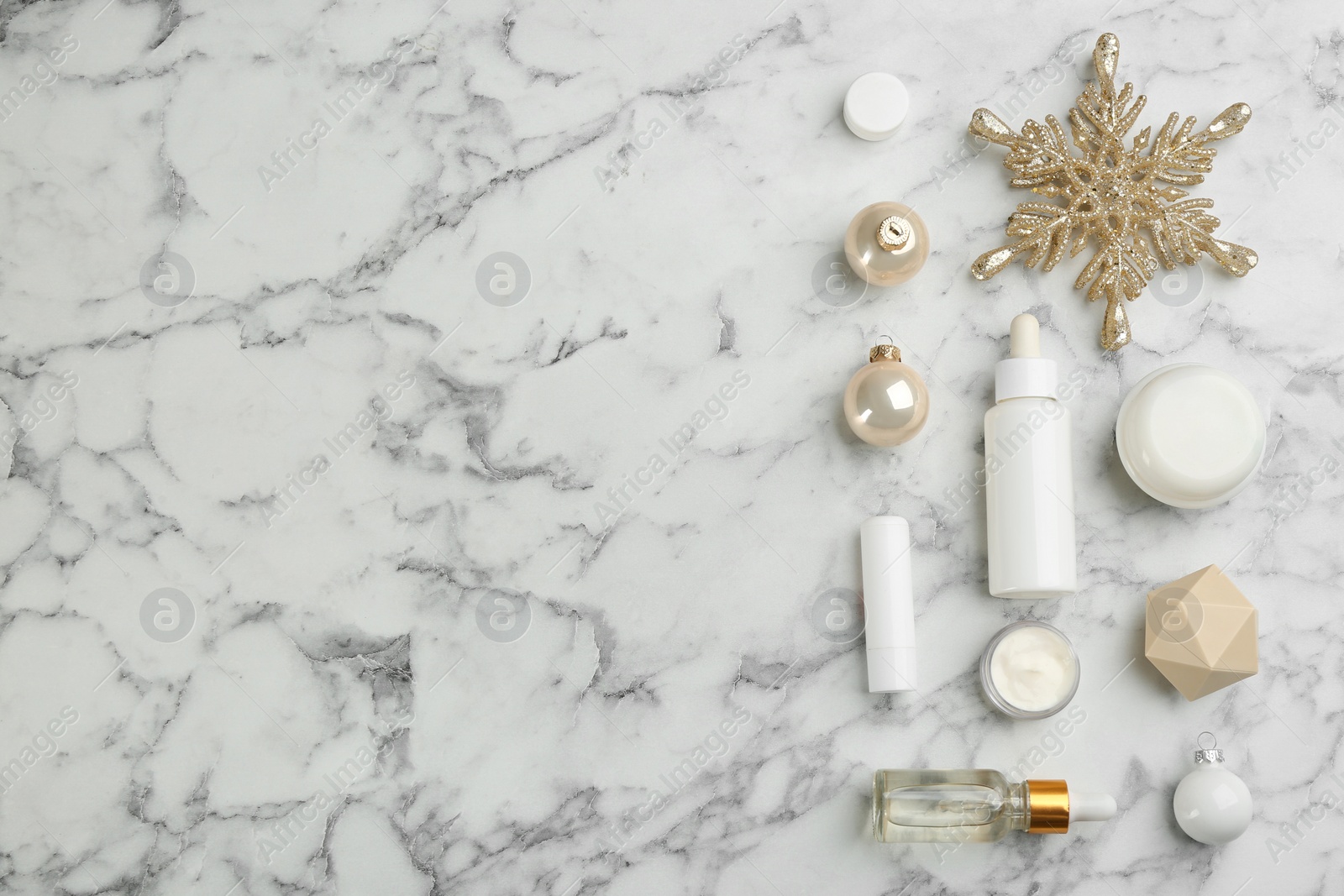 Photo of Flat lay composition with different cosmetic products on white marble table, space for text. Winter care