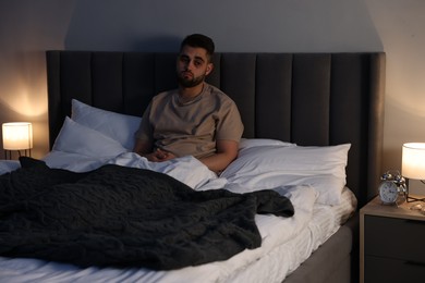 Photo of Frustrated man suffering from insomnia in bed