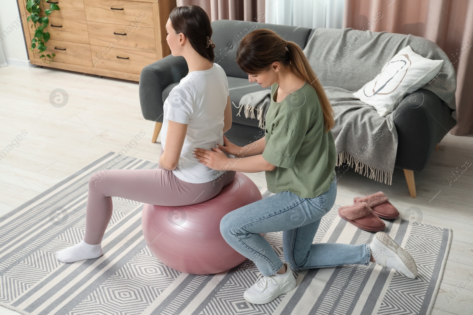 Photo of Doula massaging pregnant woman at home. Preparation for child birth