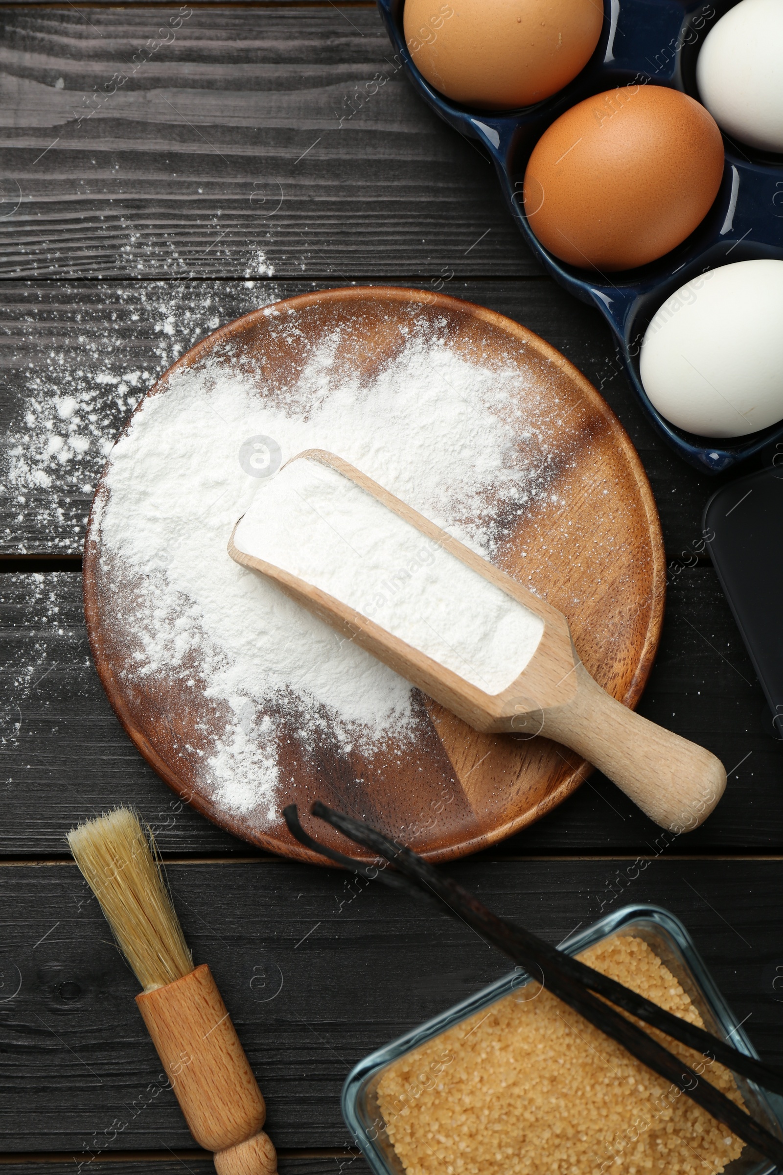 Photo of Flat lay composition with baking powder and products on black wooden table