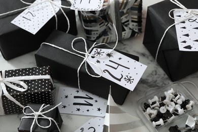 Photo of Set of gift boxes and pins on white marble table. Creating advent calendar