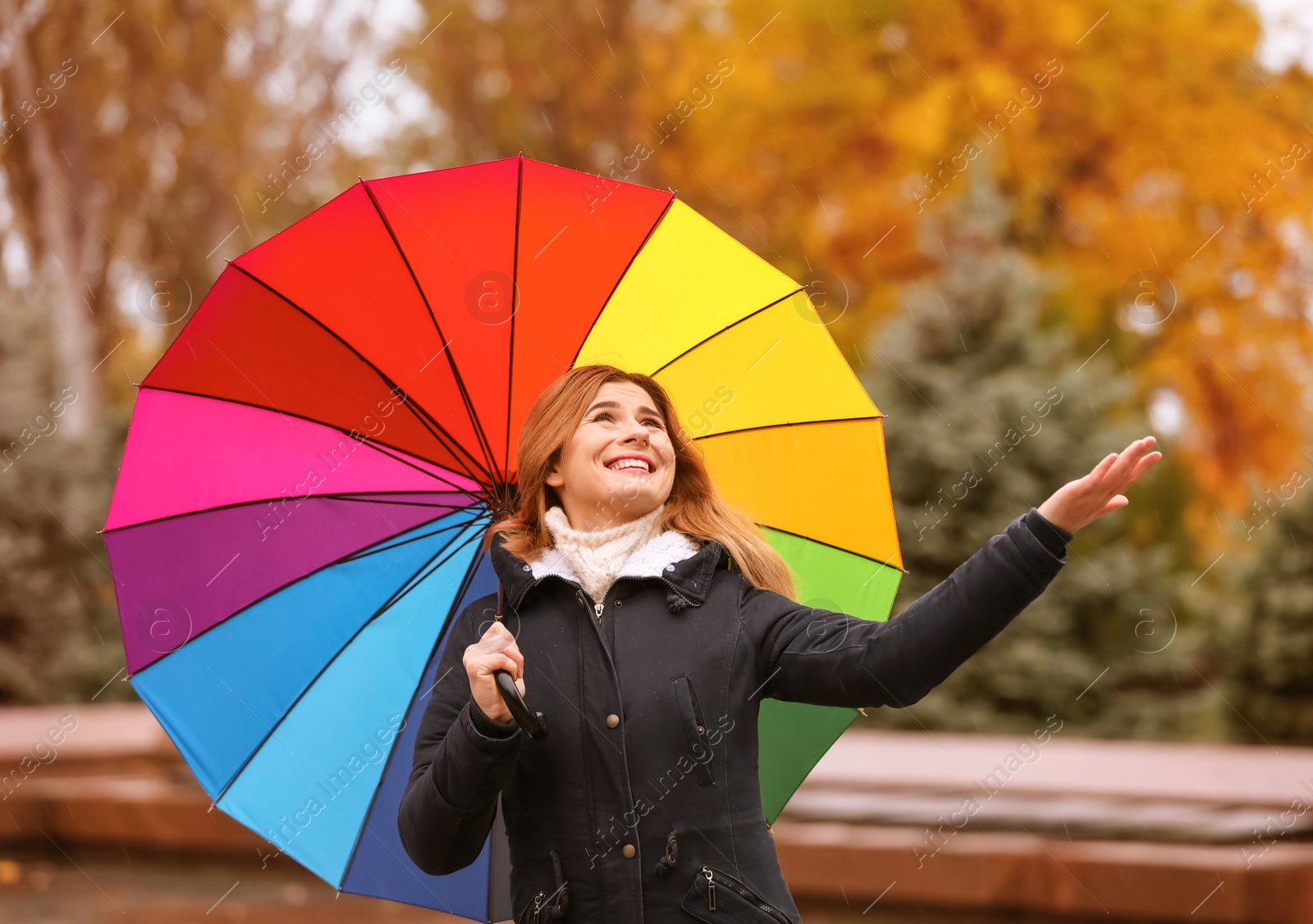 Photo of Woman with umbrella in autumn park on rainy day