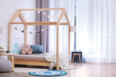 Photo of Stylish child room interior with cute wooden bed