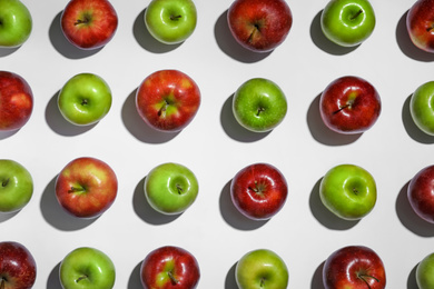 Many ripe juicy apples on white background, top view