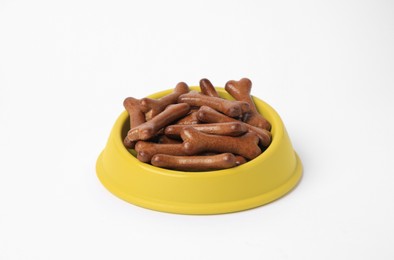 Photo of Yellow bowl with bone shaped dog cookies on white background