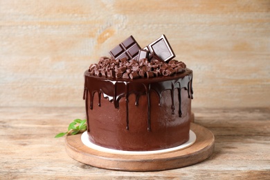 Photo of Freshly made delicious chocolate cake on wooden table