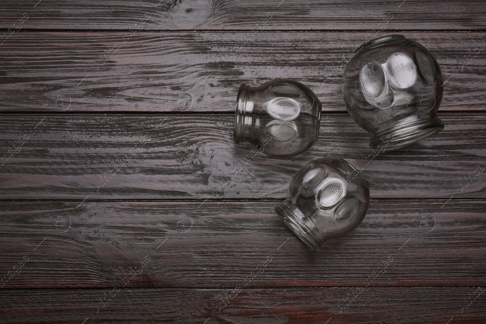 Photo of Cupping therapy. Glass cups on wooden table, flat lay with space for text