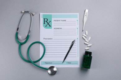 Photo of Medical prescription form, stethoscope, pills and thermometer on light grey background, flat lay