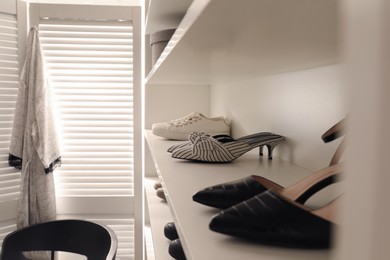 Storage rack with stylish women's shoes indoors, closeup