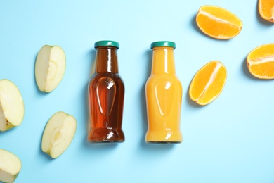 Flat lay composition with different drinks in bottles and ingredients on color background