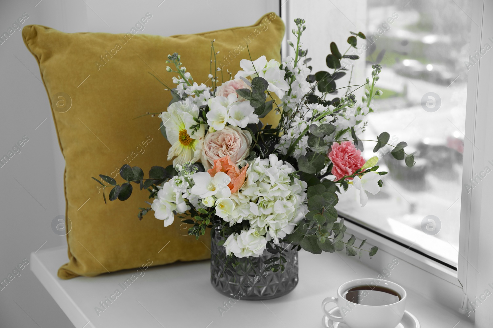 Photo of Bouquet of beautiful flowers and coffee on windowsill