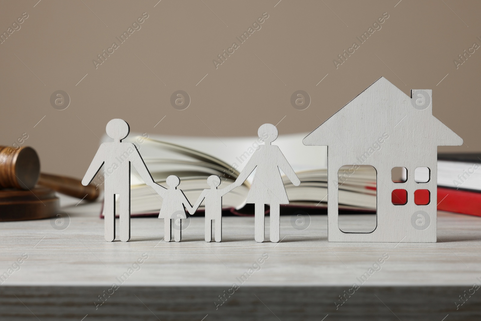 Photo of Family law. Figures of parents with children, house, books and gavel on wooden table