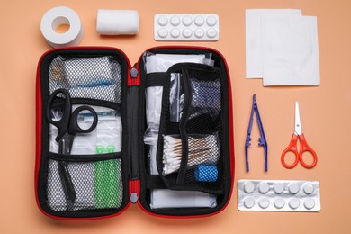 Photo of Flat lay composition with first aid kit on pale coral background