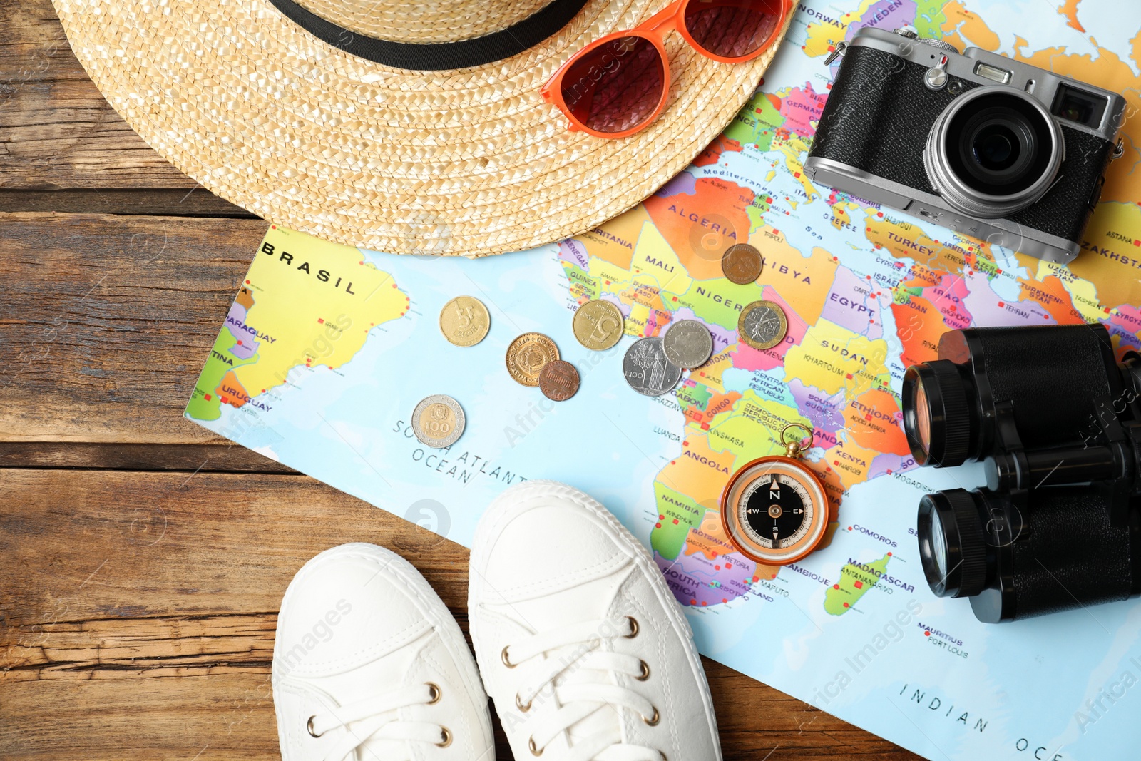 Photo of Flat lay composition with world map and different travel accessories on wooden table. Planning summer vacation trip