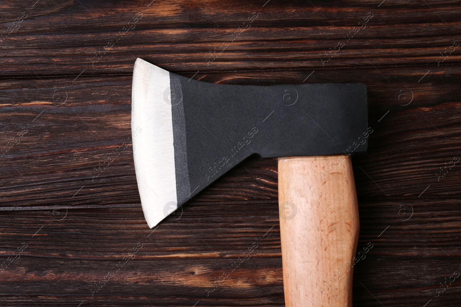 Photo of Ax with handle on wooden table, top view