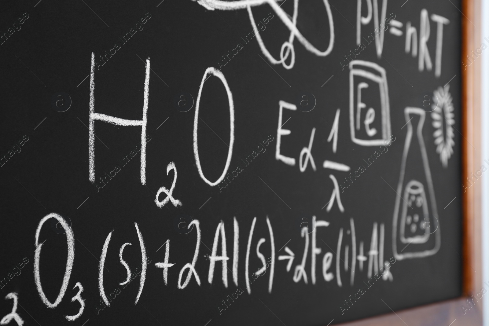 Photo of Different chemical formulas written with chalk on blackboard, closeup