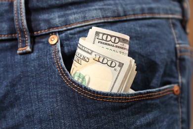 Dollar banknotes in pocket of jeans, closeup. Spending money