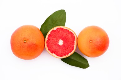 Photo of Fresh grapefruits and green leaves on white background, flat lay