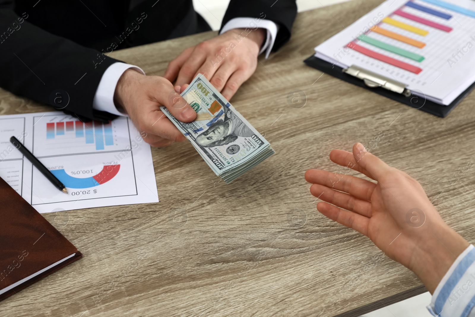 Photo of Cashier giving money to businesswoman at desk in bank, closeup