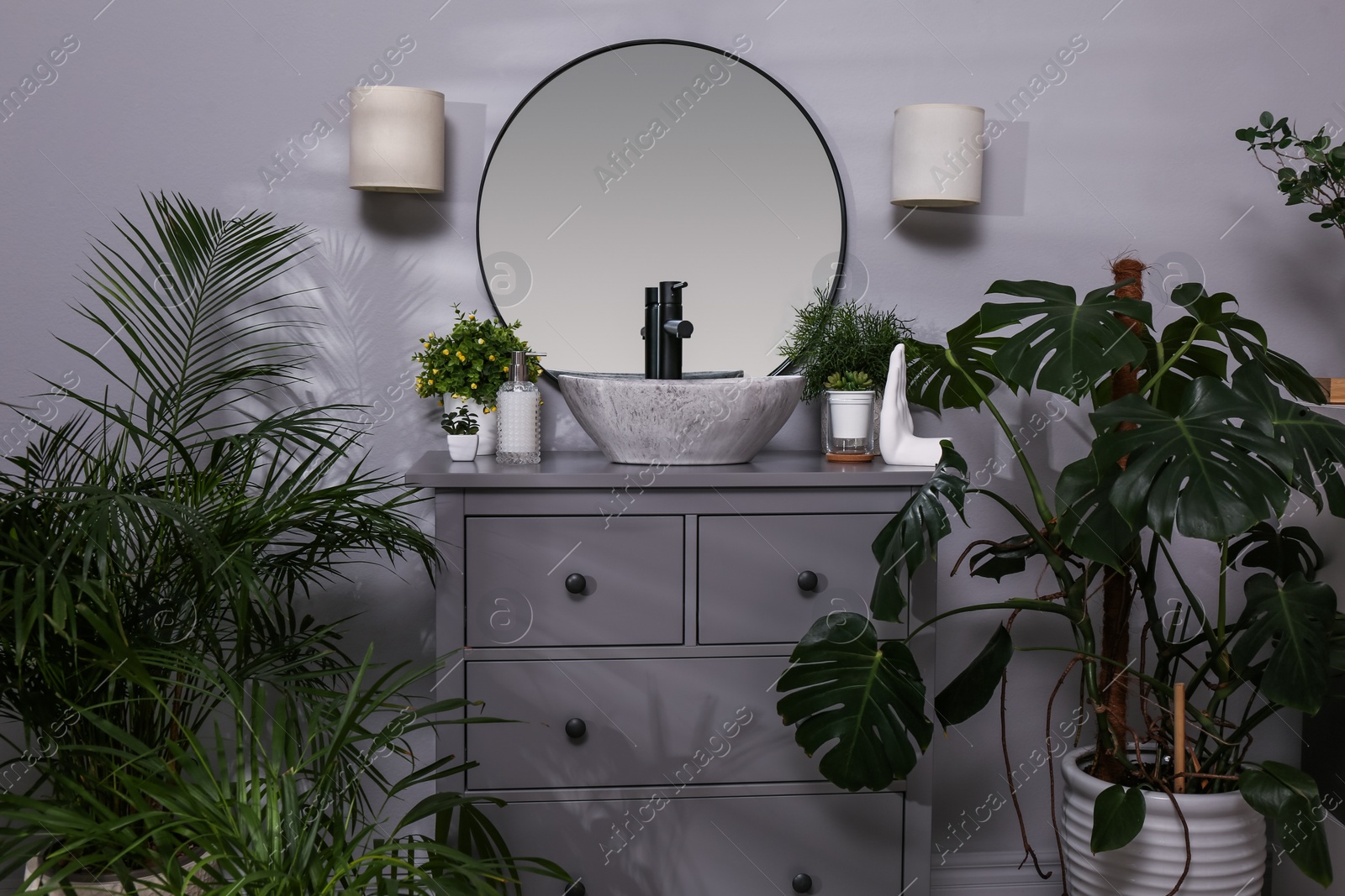 Photo of Stylish bathroom interior with modern furniture and beautiful green houseplants