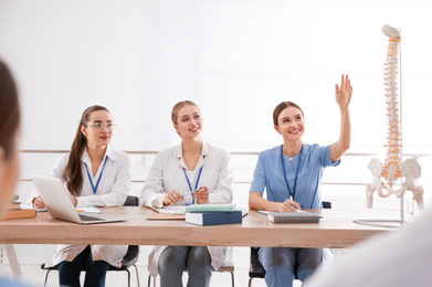 Photo of Medical students studying human spine structure in classroom