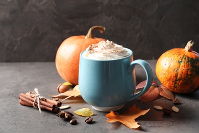 Photo of Cup with pumpkin spice latte on gray table