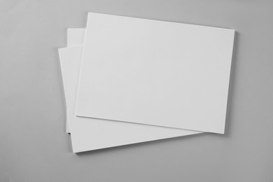 Photo of Blank brochures on grey background, top view. Mockup for design